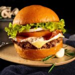 Hamburguesa Pereza: la mejor hamburguesa con salsa cremosa de champiñones y especias, tocineta, queso mozzarella, carne, pan a base de papa y vegetales frescos